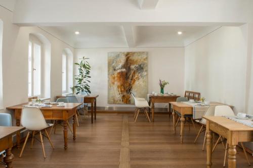 索梅拉Villa Sommerach的餐厅设有桌椅,墙上挂有绘画作品