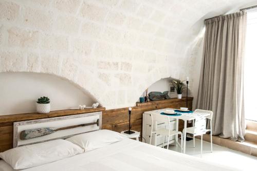 莫诺波利Borgo Albergo Capozzi 37的卧室配有白色的床和桌子