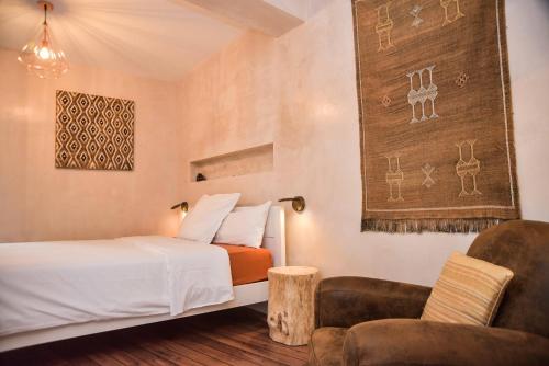 隆达布阿卜迪勒宾馆的配有一张床和一把椅子的酒店客房