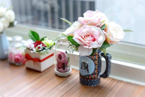 罗东镇遇巧寓可使用國旅卡有代辦泛舟賞鯨獨木舟等活動的一张桌子上装满粉红色玫瑰的花瓶