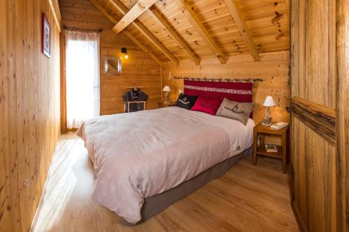 圣米舍德谢洛Chalets Shangrila的小木屋内一间卧室,配有一张大床