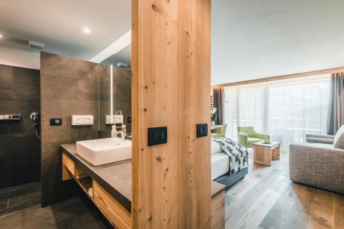 拉维拉Dolasilla Mountain Panoramic Wellness Hotel的一间带水槽的浴室和一间卧室