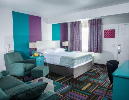 基洛纳基洛纳捷艾克森特汽车旅馆的一间卧室配有一张床、一张沙发和一把椅子