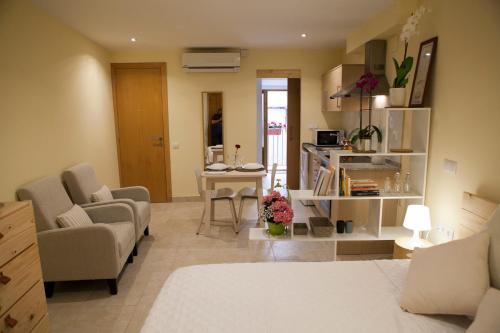 塔拉戈纳El Faro Apartaments的客厅配有床和桌椅