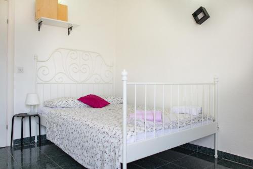 蒂瓦特Apartmani Krgušić的卧室配有白色床和粉红色枕头