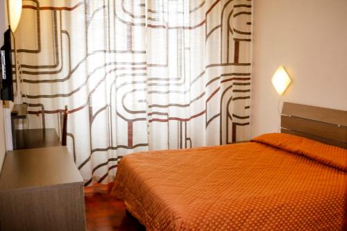 都灵吉亚塔酒店的一间卧室配有床和带窗帘的窗户