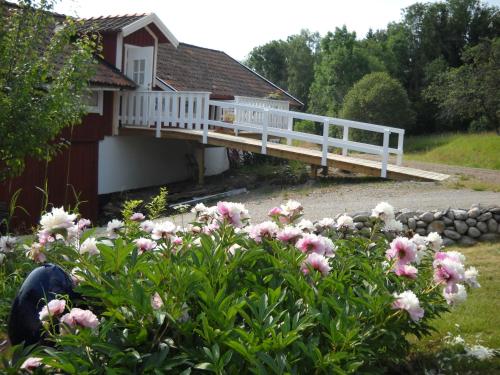 Västerlanda艾尔维贝肯酒店的白色甲板和粉红色鲜花的房子