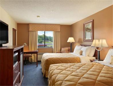 CatlettsburgRamada Hotel Ashland-Catlettsburg的酒店客房设有两张床和一台平面电视。