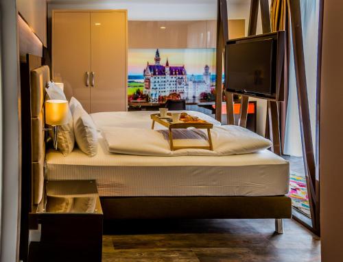 慕尼黑慕尼黑柯雷思公寓式酒店的一间卧室设有一张大床和一台平面电视。
