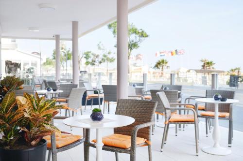 里米尼假日海滩酒店的户外休息区配有桌椅