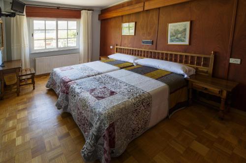 比韦罗阿斯阿雷亚斯二号酒店的一间卧室配有一张床、一张桌子和一个窗户。