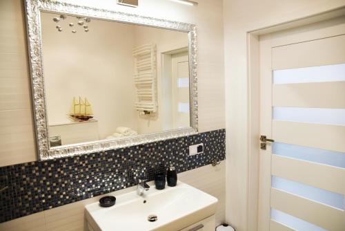 尤斯托尼莫斯基Apartament Szmaragdowy的一间带水槽和镜子的浴室