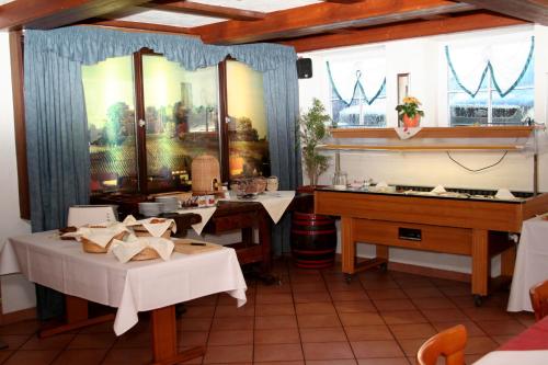 辛斯海姆库弗尔辛克酒店的一间带2张桌子和钢琴的用餐室