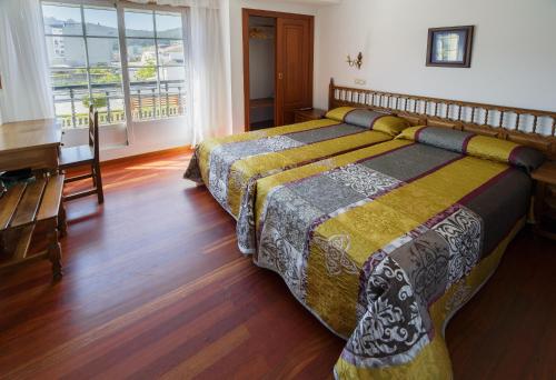 比韦罗埃斯阿雷亚斯一号酒店的一间卧室配有两张床和钢琴
