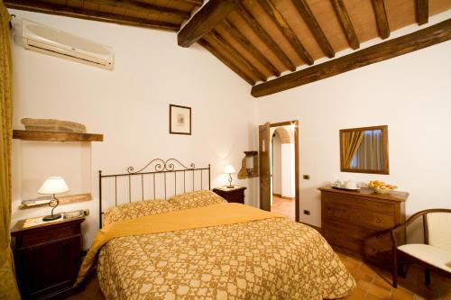 科尔托纳Fattoria Borgonuovo的卧室配有1张床、1张桌子和1把椅子