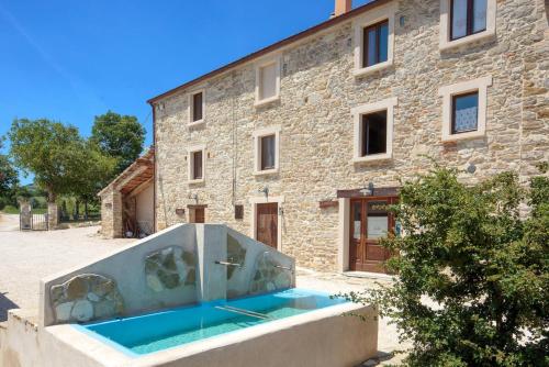 Frontino戴杜波尔帝乡村民宿的一座石头房子,在一座建筑前设有一个游泳池