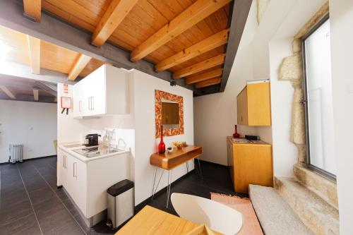 维塞乌Antiga Casa da Burra的厨房配有白色橱柜和木制天花板