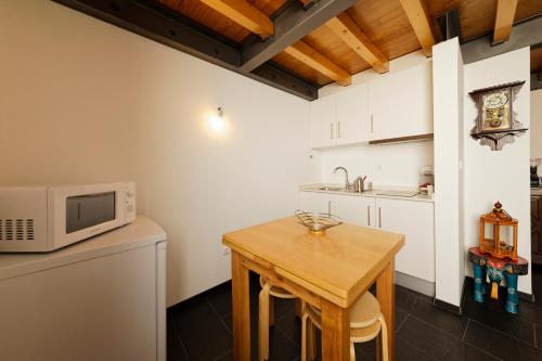 维塞乌Antiga Casa do Boi的厨房配有木桌和微波炉
