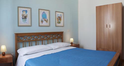 圣凯撒利亚温泉Fico d'India的一间卧室配有一张蓝色的床,墙上有三张照片