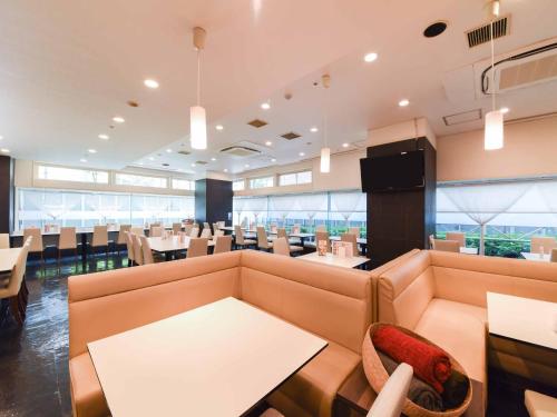 神户神户三宫联盟酒店的一间带沙发和桌子的餐厅以及一间用餐室