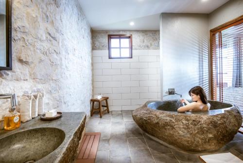 萨帕滔帕斯生态酒店的坐在浴室大浴缸中的女人