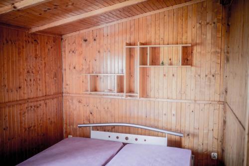 ŁuszczewoHacjenda的小房间,木墙里设有一张床