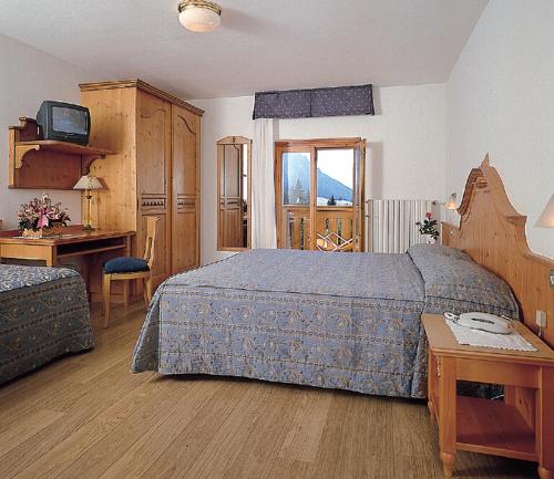 圣马蒂诺-迪卡斯特罗扎约兰达酒店的一间卧室配有一张床、一张书桌和一台电视
