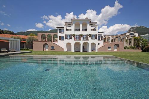 托斯科拉诺-马德尔诺Le Selve Lake View Villas的一座大房子,前面设有一个游泳池