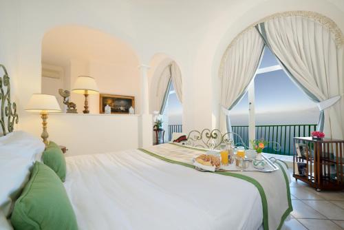 阿纳卡普里西泽奥古斯都酒店的一间卧室配有一张带桌子和食物的床