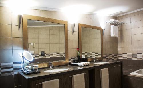 朱尼耶The Rooms Boutique Hotel的浴室设有2个水槽和2面镜子