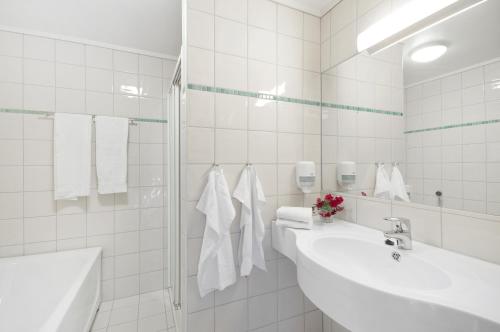 法尔松法松德福约德酒店的白色瓷砖浴室设有2个盥洗盆和淋浴。