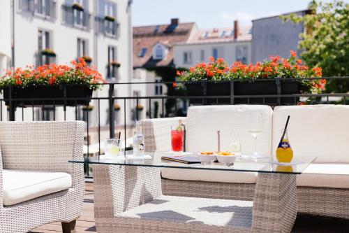 波茨坦波茨坦勃兰登堡门酒店的鲜花阳台的玻璃桌子和椅子