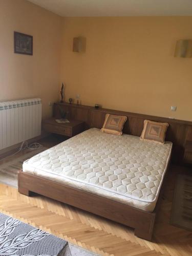 希普卡Davidkov Holiday Home的铺有木地板的客房内的一张大床