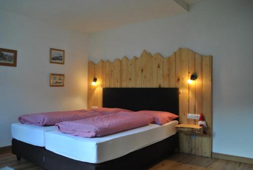 弗利斯Chasa Chalur的一间卧室设有一张带木墙的大床