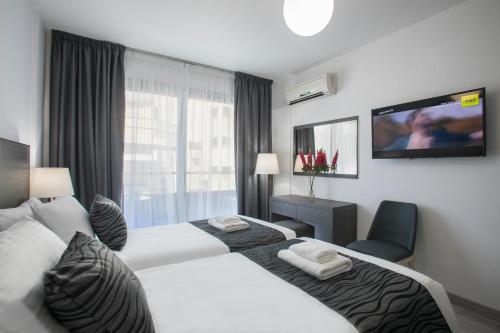 拉纳卡开拓者公寓式酒店的酒店客房设有两张床和一台平面电视。