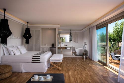 玛利亚玛利亚太阳村套房精品公寓式酒店的一间带白色床的卧室和一间浴室