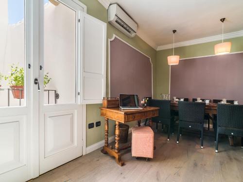 卡洛福泰Charming Rooms Opuntia的用餐室配有带笔记本电脑的桌子