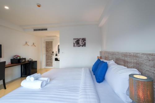 普吉镇Xinlor House - Phuket Old Town的一间卧室配有一张带蓝白色枕头的大床