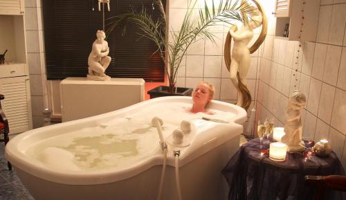 Legde乐格德福利酒店的浴室配有带雕像的浴缸。