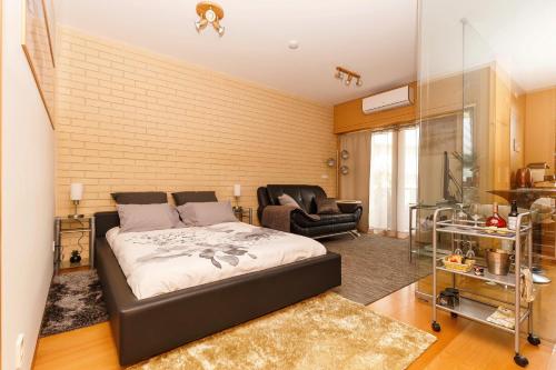 加亚新城Studio Apartment Porto Gaia (Arrabida)的一间卧室,卧室内配有一张床和一把椅子