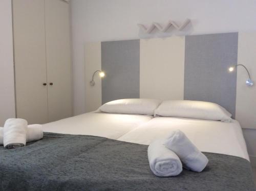 圣塞瓦斯蒂安Alderdi Eder的卧室配有白色床和毛巾