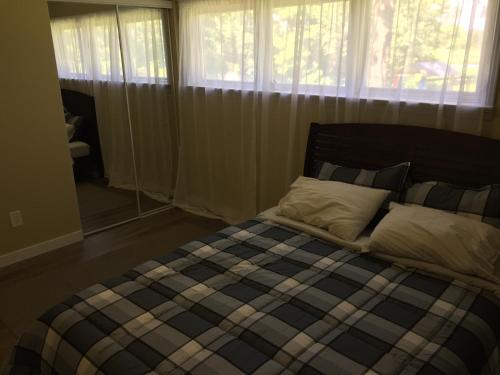 渥太华松树景别墅的卧室配有带枕头和窗户的床。