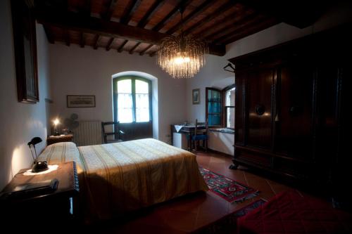 圣朱利亚诺-泰尔梅Agriturismo La Grotta的一间卧室配有一张大床和一个吊灯。