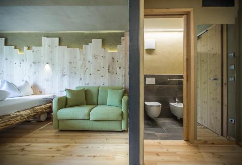 新黎凡特黛安娜自行车滑雪酒店的一间带绿色沙发的客厅和一间浴室