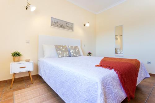 拉戈斯Casa Lagos的卧室配有白色的床和床头柜