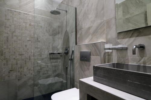 波利伊罗斯Klities Guest House的一间带玻璃淋浴和水槽的浴室