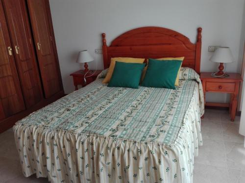 桑亨霍Apartamentos Esther的一间卧室配有一张带绿色枕头的大床