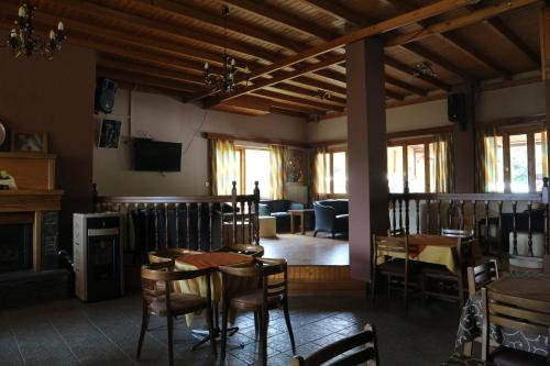 AthamanioHotel Elatofilito的一间带桌椅和壁炉的用餐室
