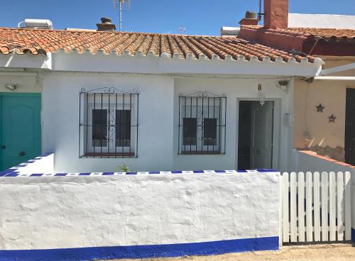 博罗尼亚Sol de Bolonia 8的白色的房子,设有铁窗和白色的围栏