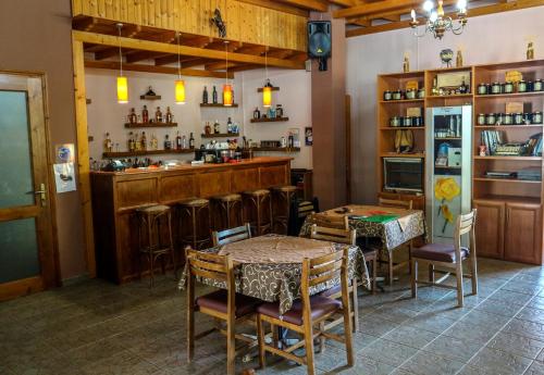 AthamanioHotel Elatofilito的一间带桌椅的餐厅和酒吧